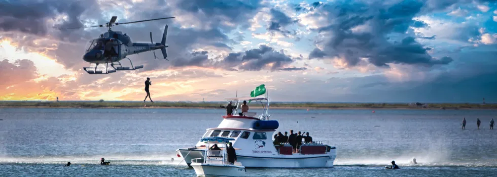 Helicopter jump into water at hawaii sunset