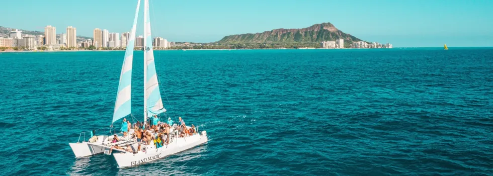 Small waikiki catamaran with blue sails