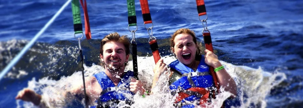 Couple dipped in ocean while parasailing