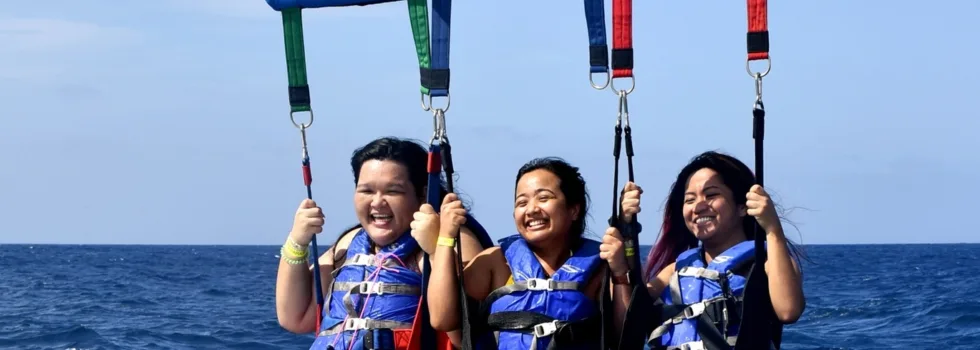 Friends smiling while waikiki parasailing