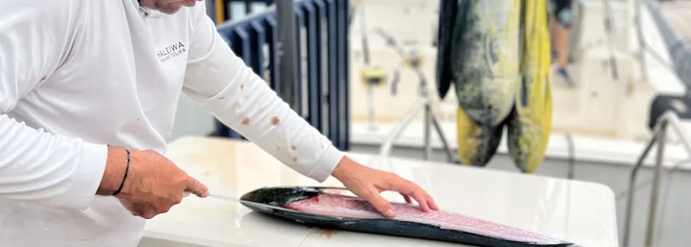 Man filets fish after waikiki fishing charter