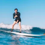 Smiling surfer rides wave in waikiki