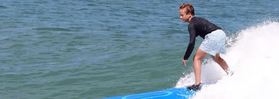 Boy catches wave during private surf lesson