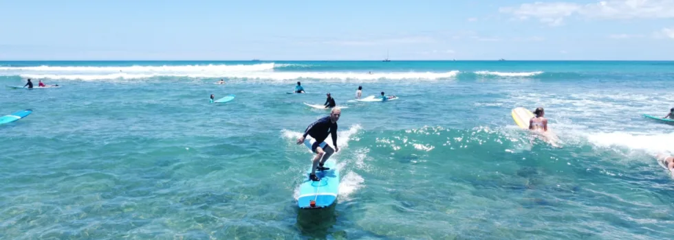 Surfer learning to ride waves in waikiki