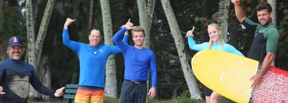 Surf instructors and guests throwing shakas