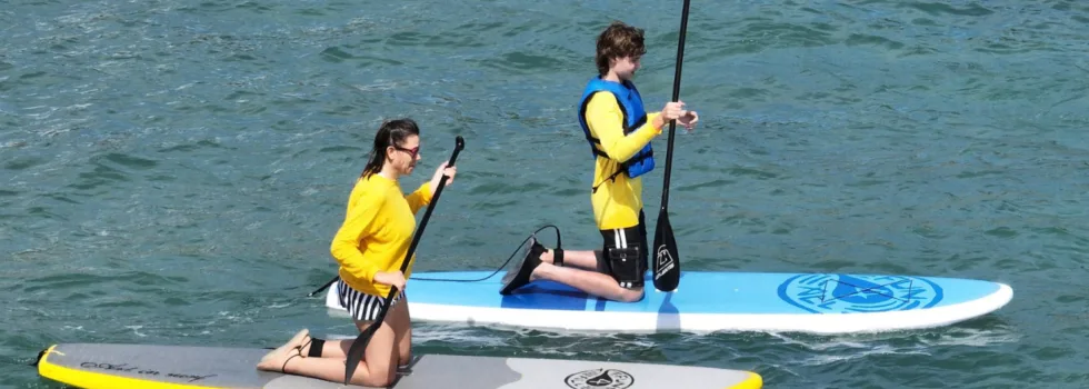 Couple kneeling on waikiki stand up paddle board