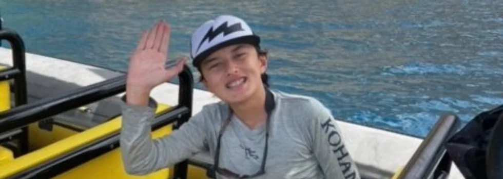 Boy waving on kona boat