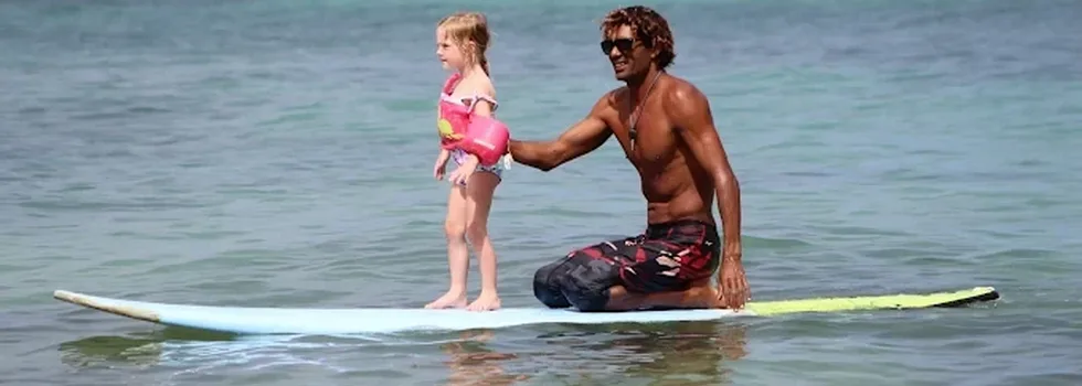 Little girl with surf instructor hawaii