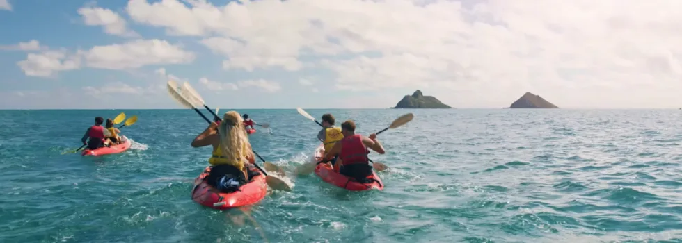 Red kayaks paddling to mokulua islands