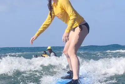 Learn to Surf at Poipu Beach: Girl riding wave in poipu thumb