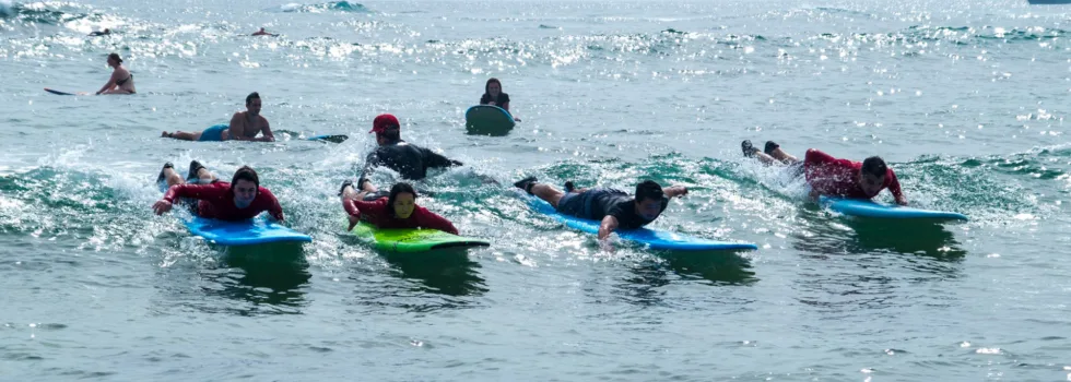 Four surf lesson students paddling kauai