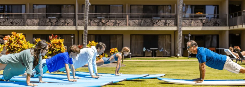 Surf instructor teaching pop up on land poipu
