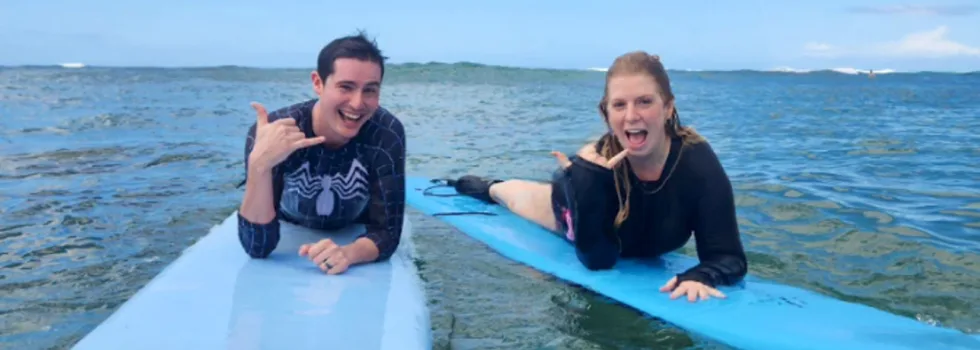 Surf students laying on board giving thumbs up kauai