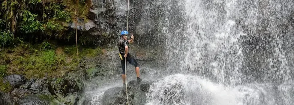 Lady rappells kauai waterfall happy