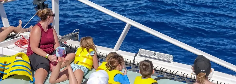 Kids sitting on the catamaran net west oahu