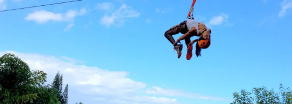 Woman does back bend on maui zipline