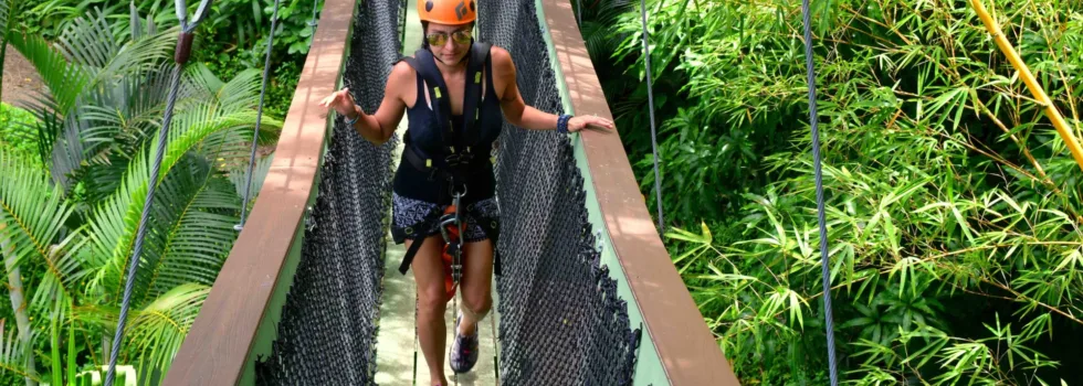 Zipline guest walks across hanging bridge