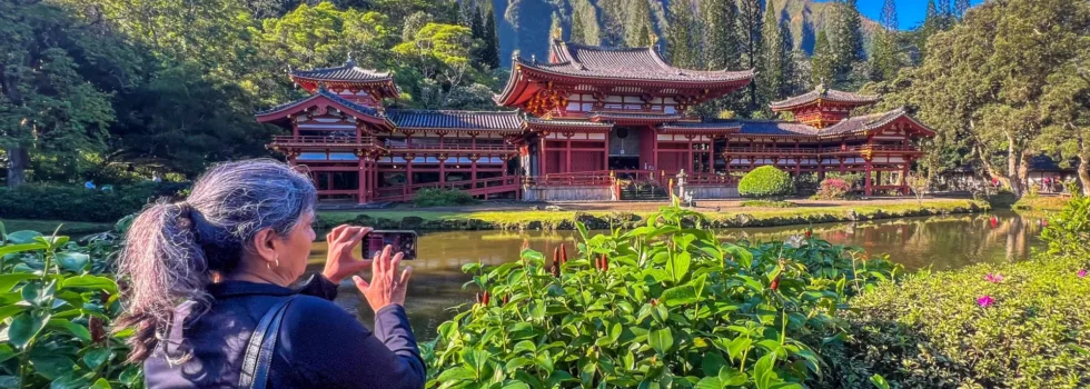 Woman photographing byodo in temple