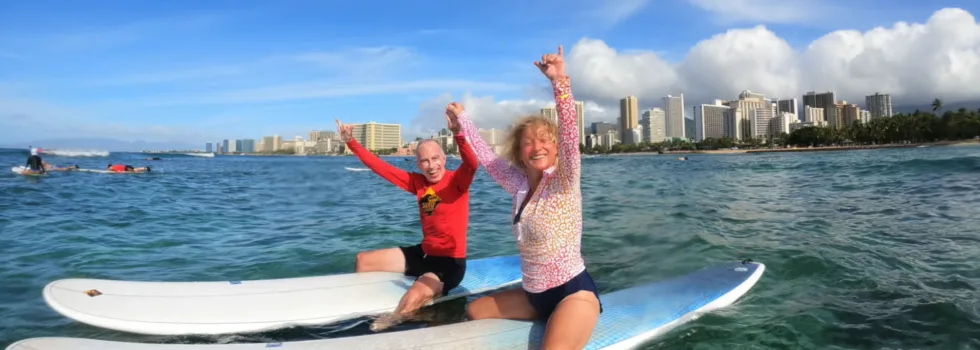 Retired couple sitting on surf lesson boards waikiki