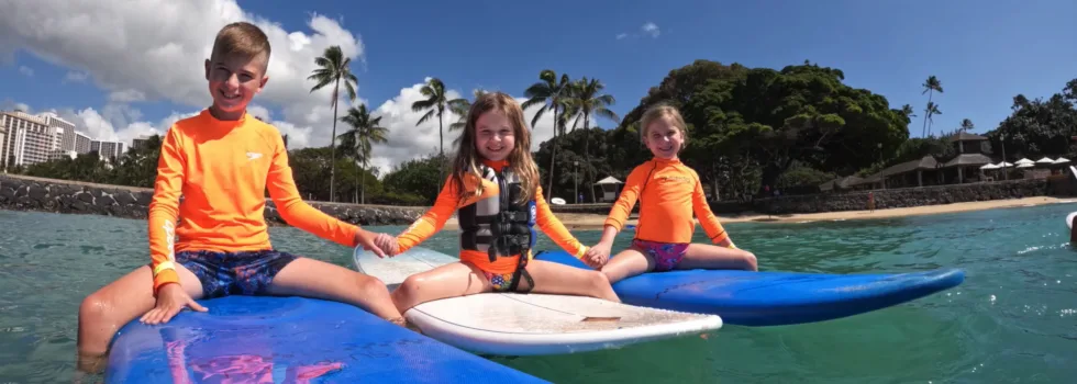 Siblings sitting on waikiki surfboards
