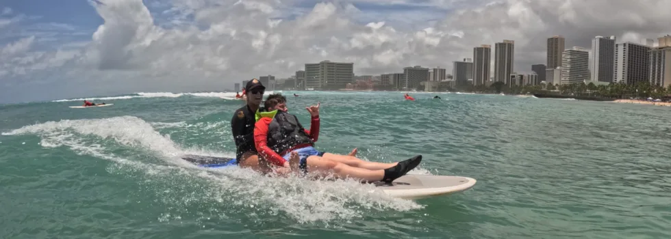Surf instructor helps adaptive surf lesson