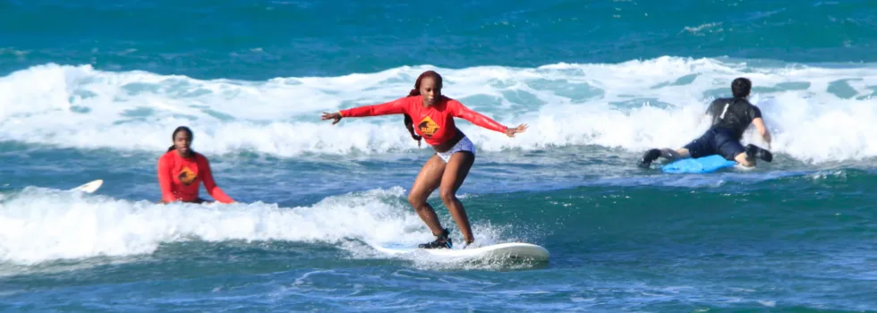 Woman balances while surfing waikiki