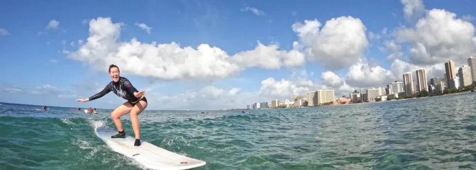 Woman riding surf lesson wave waikiki