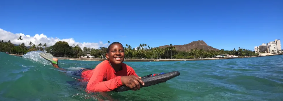 Boy smiles while bodyboard hawaii
