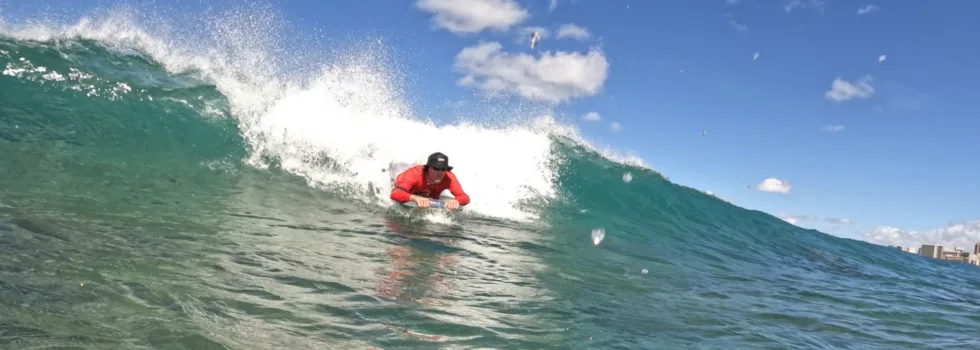 Man riding wave boogie board hawaii