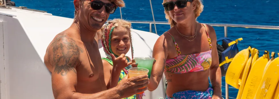 Family sipping cocktails during waikiki catamaran