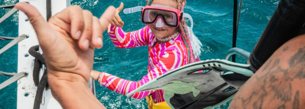 Little girl entering snorkel water waikiki