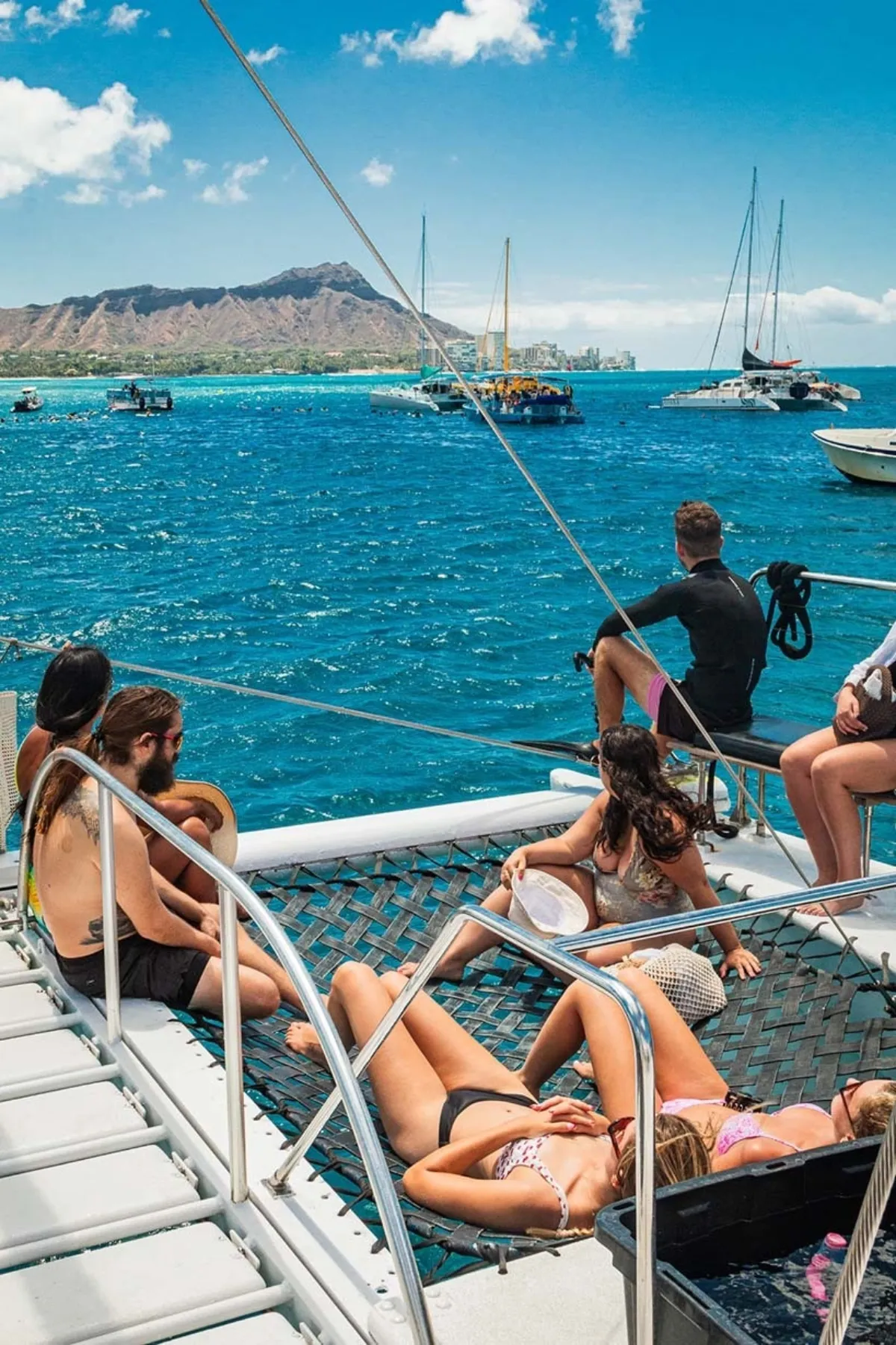 Guest relaxing on the desk of catamaran post snorkeling on catamaran