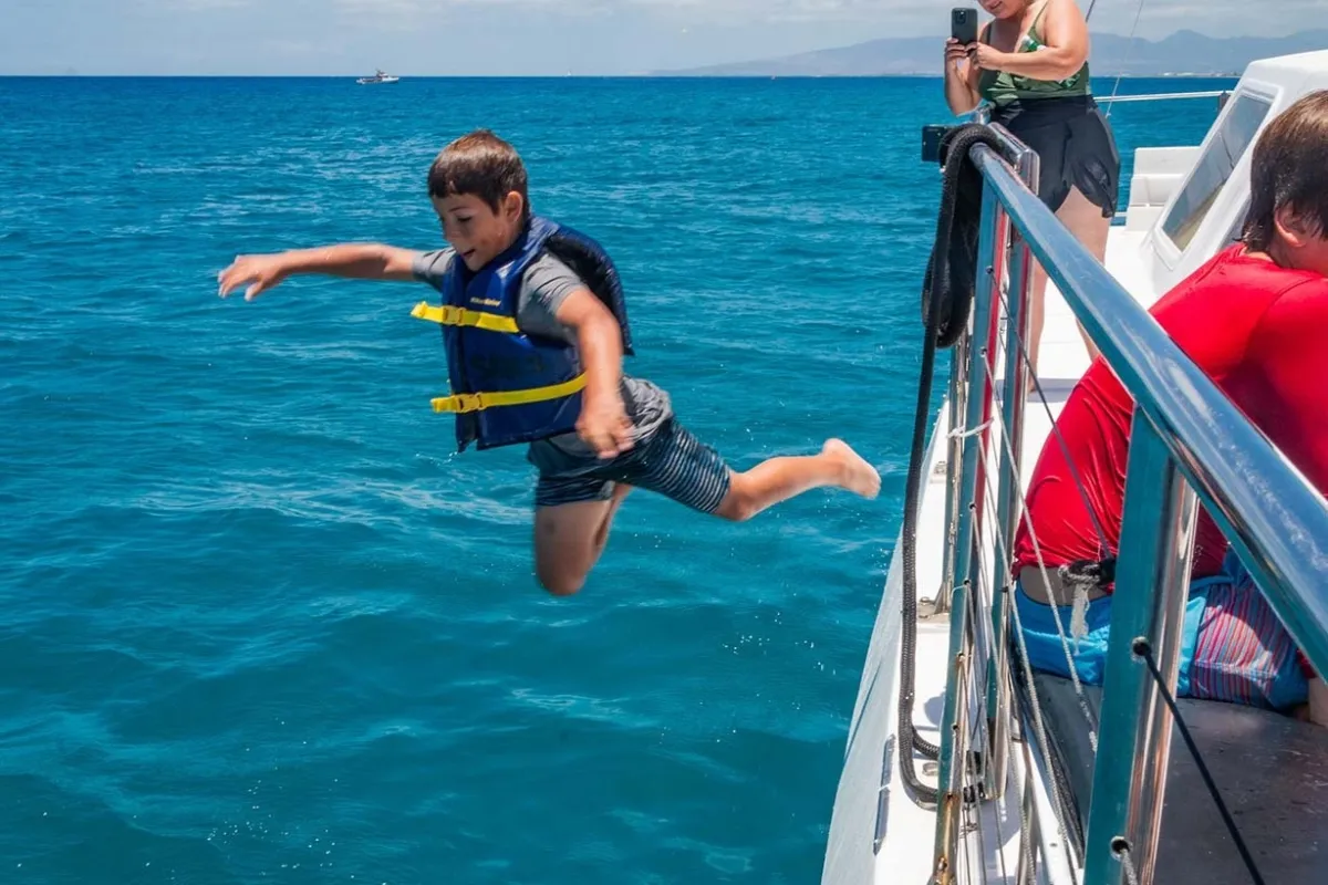 Kid jumping off catamaran outside of Waikiki