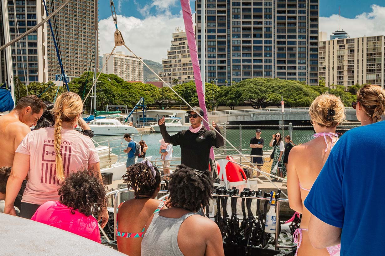 Tourists preparing snorkel gear on catamaran before Waikiki excursion